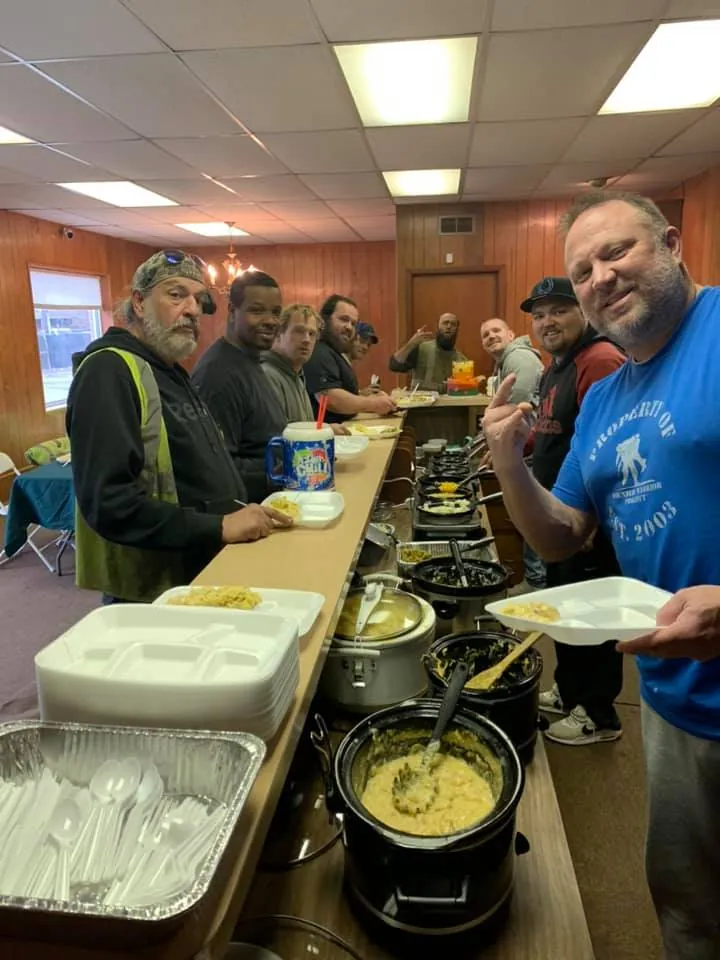 The New Country Auto Parts crew sharing a team lunch between pulls -- the staffing that makes full-service junkyard shopping work