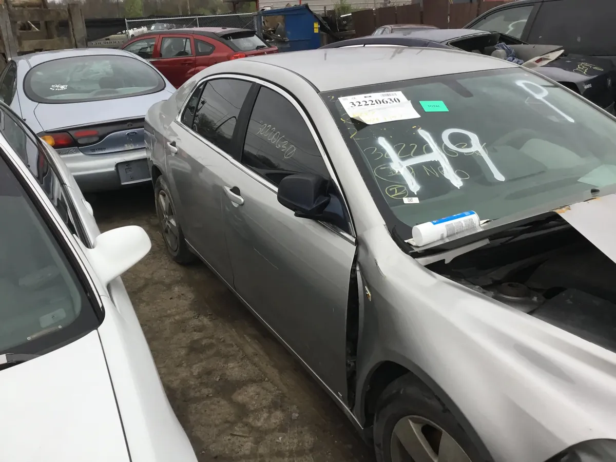 Vehicle with hood open being evaluated for parts at an Indianapolis salvage yard