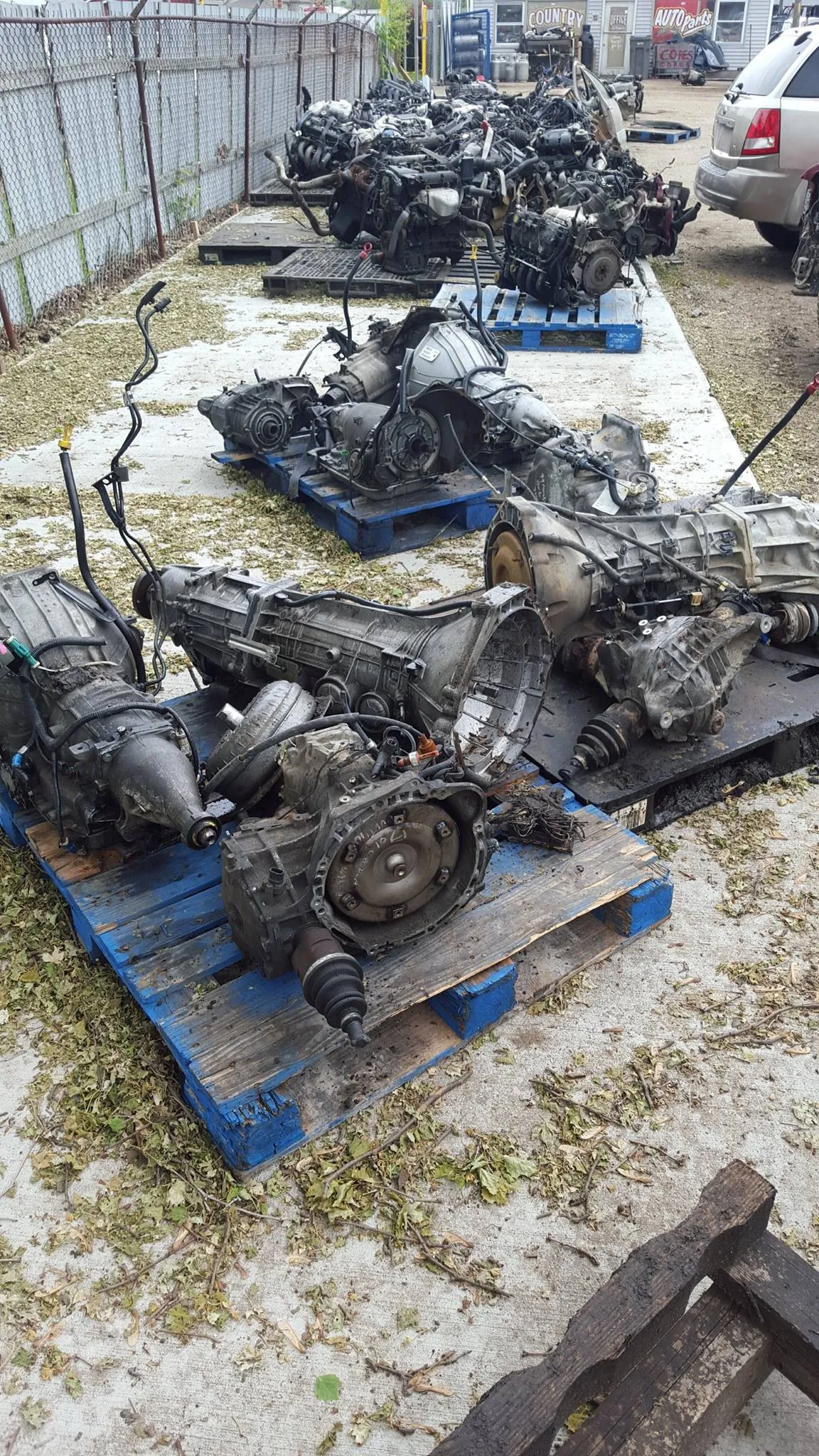 Pulled engines and transmission cores staged on pallets outside the TNCAP office -- major components carry core charges
